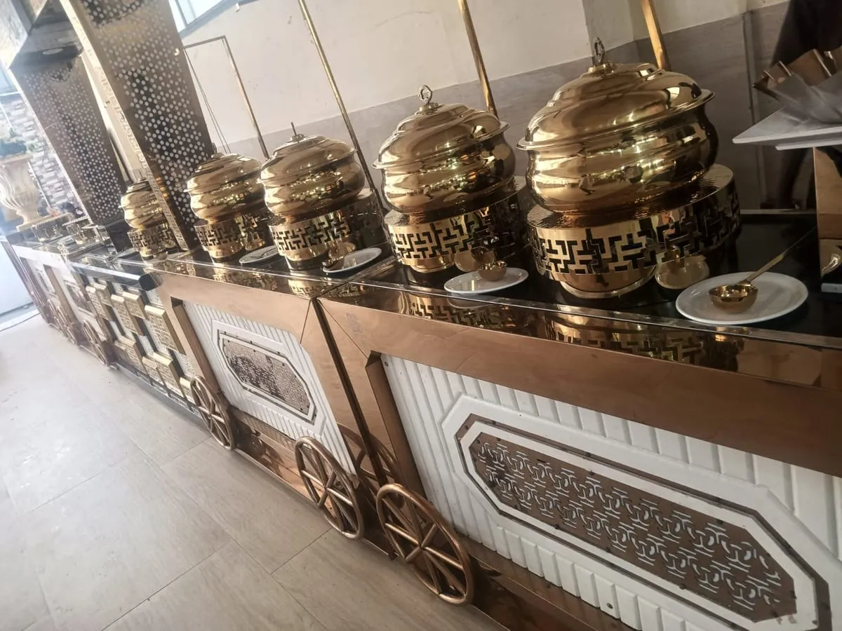 Brass handis lined up on a buffet counter