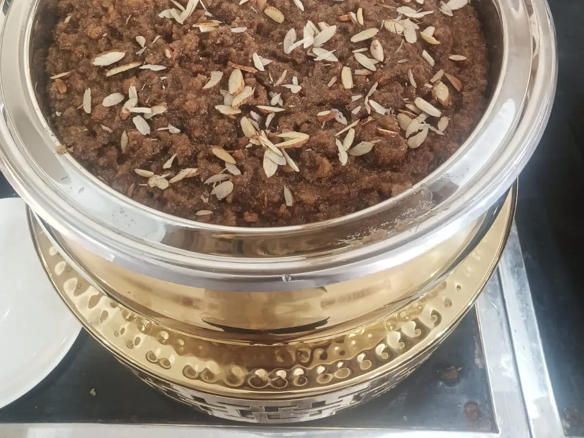 Churma topped with almond slivers in a serving handi