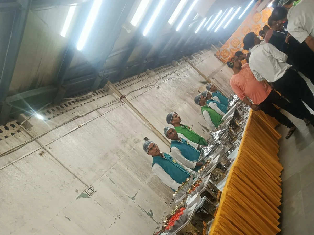 Guests seated in rows being served a full meal