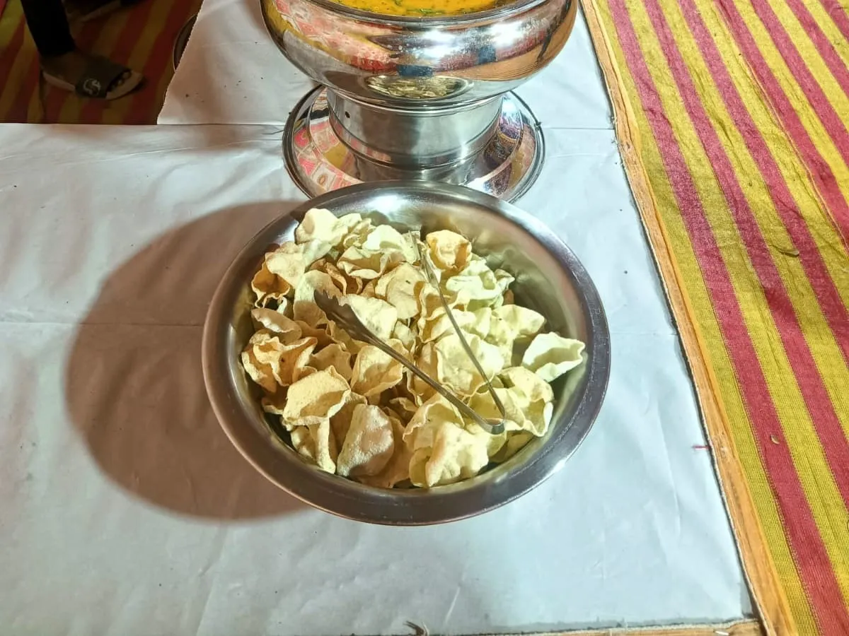 Outdoor buffet with chafing dishes of dal, rice and papad