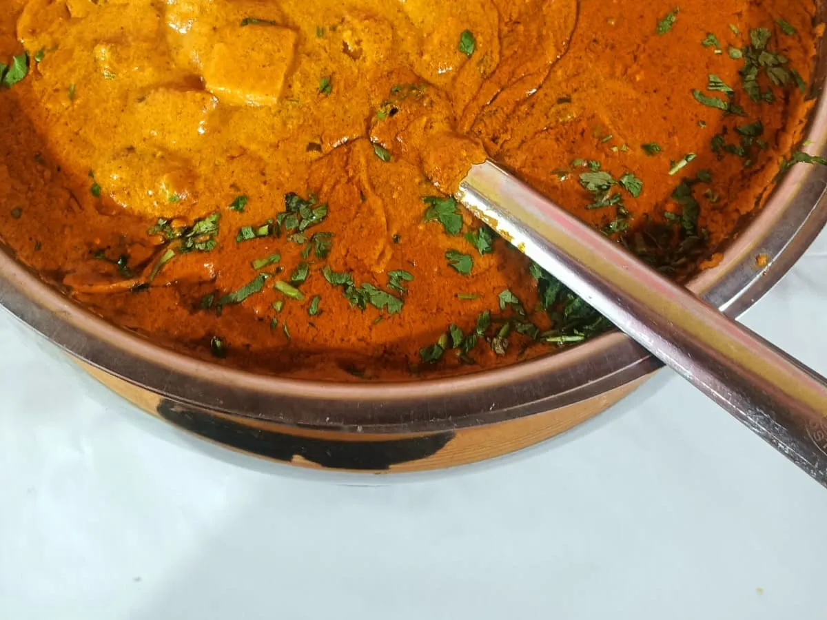 Paneer butter masala served in a copper bowl