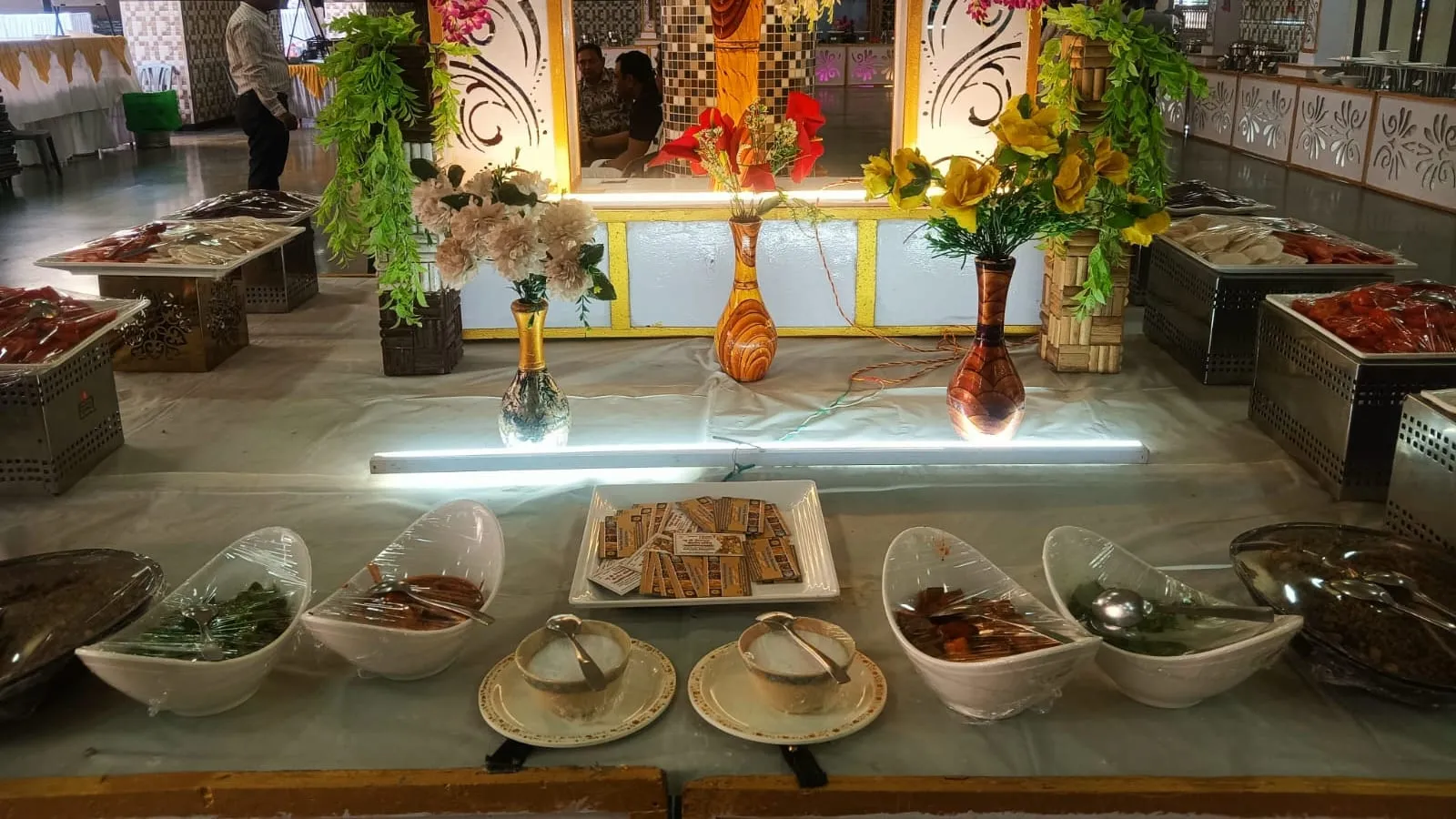 Indian wedding buffet line with chafing dishes and marigold flowers