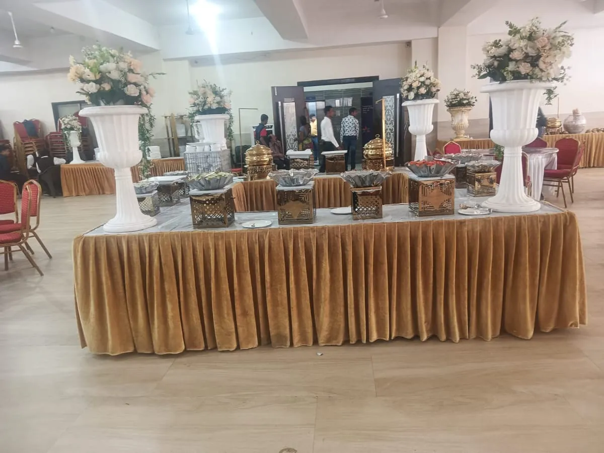 Wedding buffet table with gold skirting and tall flower vases
